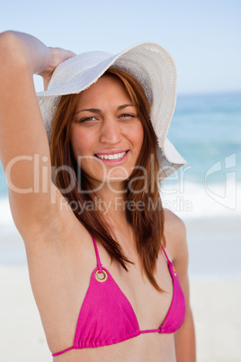 Smiling teenager posing in front of the sea while holding her ha