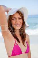 Smiling teenager posing in front of the sea while holding her ha