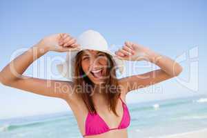 Young woman raising her arms in happiness in front of the sea