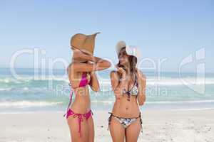 Attractive teenagers standing in front of the sea in beachwear