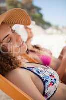 Beautiful woman napping on the beach on a deck chair