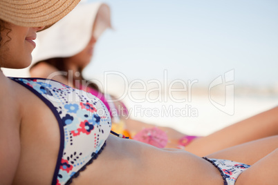 Attractive young woman in bikini lying on the beach