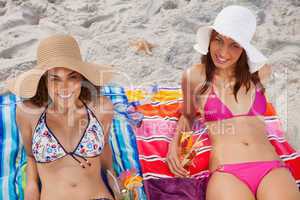 Smiling women looking at the camera while sunbathing