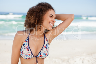 Young woman placing her hand on her hair while wearing a swimsui