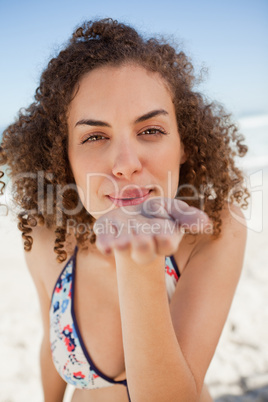 Young woman blowing a kiss while staring at the camera