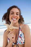 Smiling young woman proudly holding a starfish