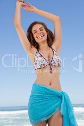 Smiling young woman raising her arms to show her happiness