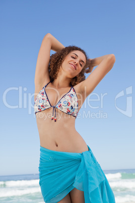 Young woman standing in front of the sea while showing her welln
