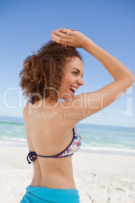 Young woman showing her happiness in front of the sea
