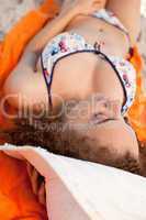 Young relaxed woman napping on her beach towel