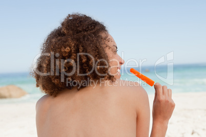 Smiling attractive woman holding an orange ice lolly