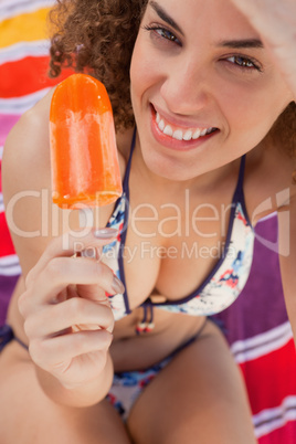 Young smiling and attractive woman holding a delicious ice lolly