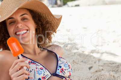 Smiling woman showing a beaming smile while holding an ice looly