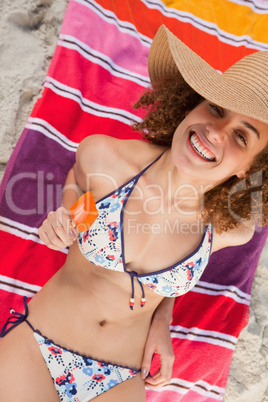 Overhead view of an attractive woman in bikini holding an orange