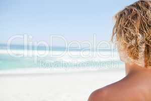 Young blonde man looking at the sea while sunbathing