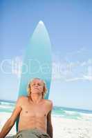 Young relaxed man sitting on the beach while sunbathing