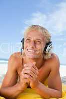 Smiling man looking up while listening to music with his headset