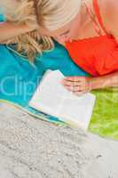 Overhead view of a blonde woman reading a book
