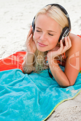 Young woman closing her eyes while listening to music on her bea
