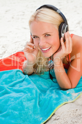 Smiling young blonde woman looking at the camera while listening