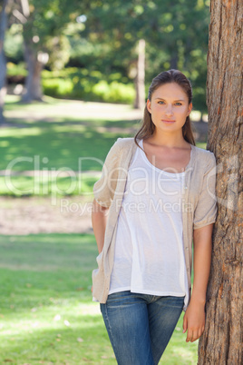 Woman resting against a tree