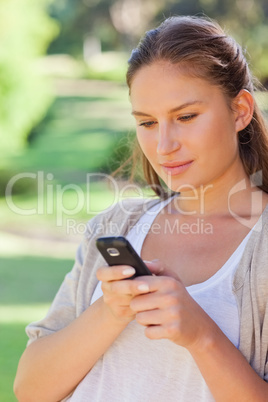 Close up of woman writing a text message in the park