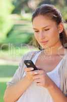 Close up of woman writing a text message in the park