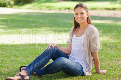 Smiling woman sitting on the lawn Smiling woman sitting on the lawn