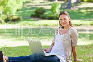 Woman with her laptop sitting on the lawn