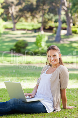 Smiling woman with her notebook in the park