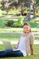 Smiling woman with her notebook in the park