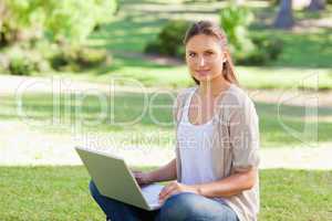 Woman with her laptop sitting on the grass