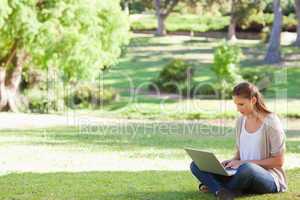 Woman sitting on the lawn working on her notebook