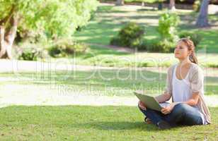 Woman sitting on the meadow with her notebook