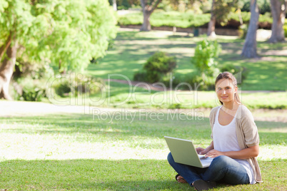 Woman with her laptop sitting in the park