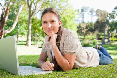 Woman lying on the lawn with her notebook