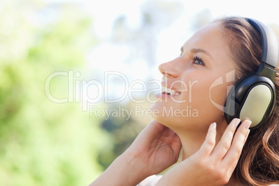 Side view of a woman in the park listening to music