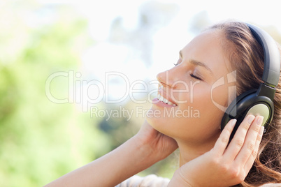 Side view of a woman enjoying music in the park