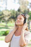 Woman with headphones enjoying music in the park
