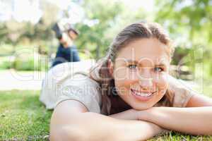 Smiling woman lying on the lawn