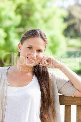 Smiling woman sitting on a bench in the park