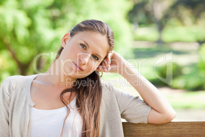Thoughtful woman sitting on a park bench