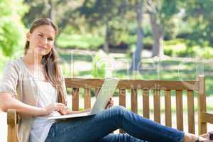 Woman with her laptop on a park bench