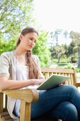 Woman with a tablet computer sitting on a bench