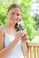 Smiling woman with a flower sitting on a bench