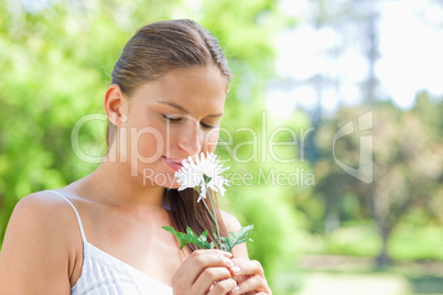 Woman smelling on a flower in the park