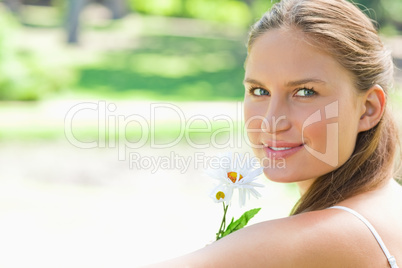 Side view of woman with a flower in the park