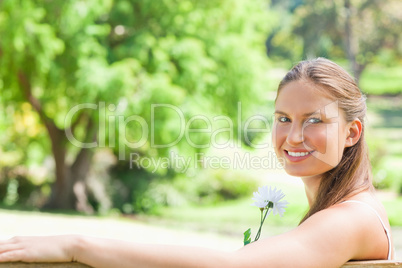 Side view of a smiling woman with a flower