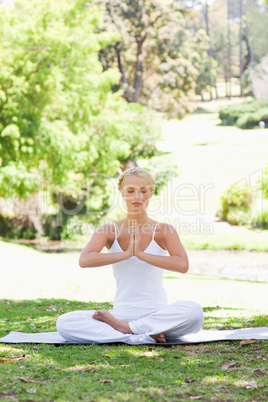 Woman in a yoga position sitting on the lawn