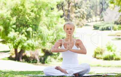 Woman in a yoga position sitting in the park